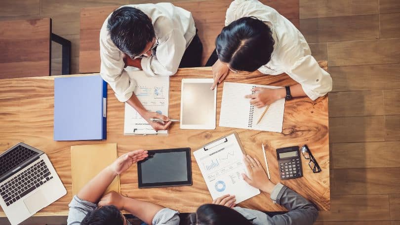 Groups of professionals around a table in a meeting